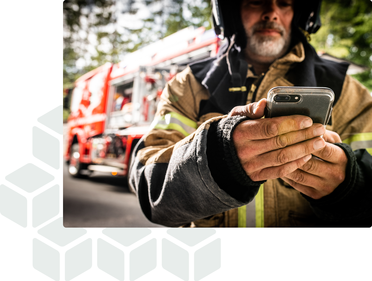 Brandman står framför brandbilen och använder GRID för att kontrollera utrustning