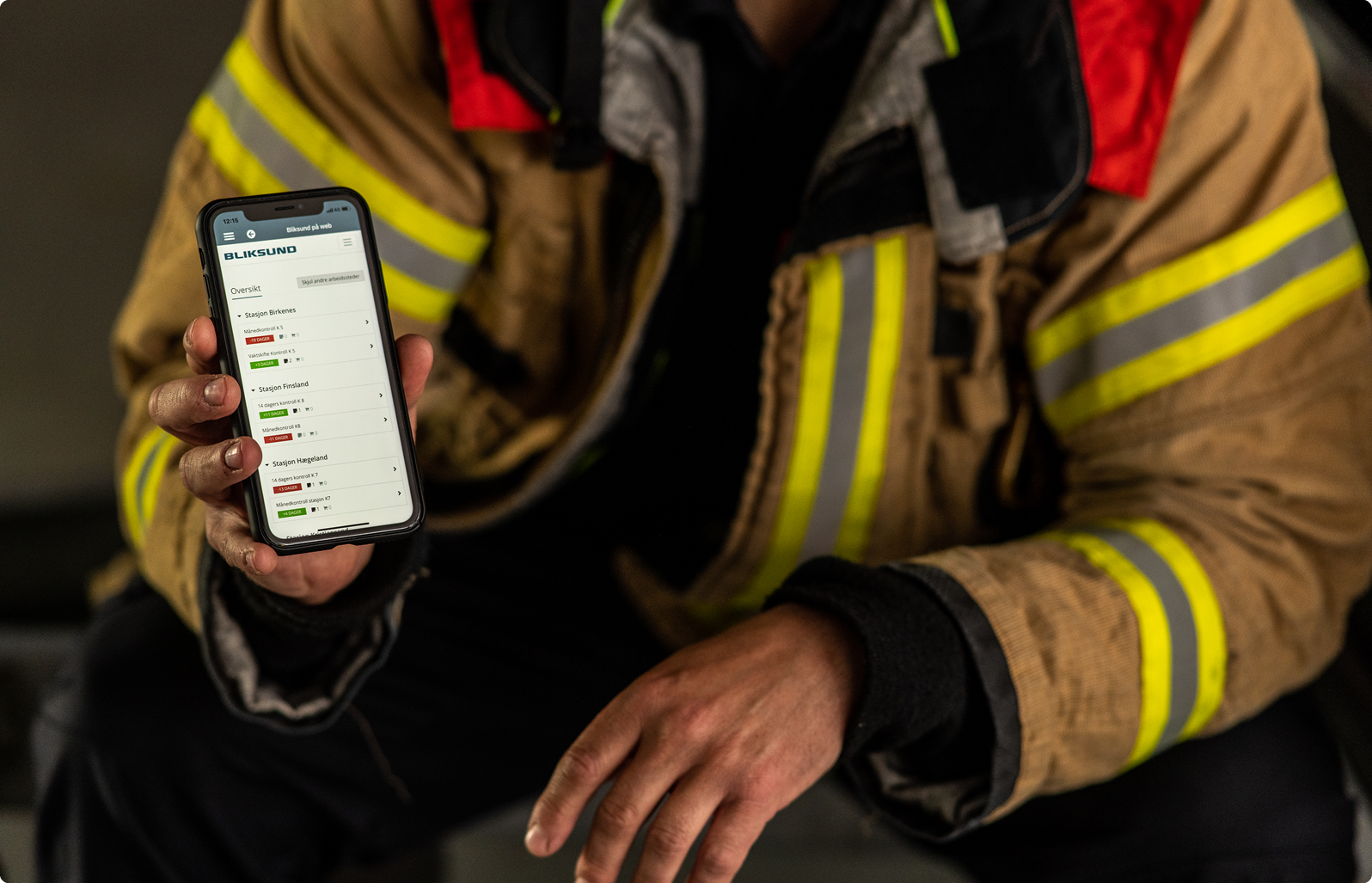 Brandman visar upp det operativa professionella systemet GRID på en smartphone